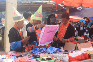 Những phụ nữ Dao bên món hàng mình ưng ý, có lễ bà ấy đang chuẩn bị mua